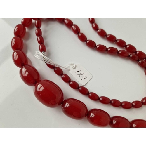 129 - A STRING OF CHERRY AMBER BEADS 28 INCH 54 GMS