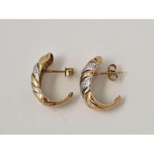 658 - A pair of curled earrings with tiny diamonds 9ct 4 gms