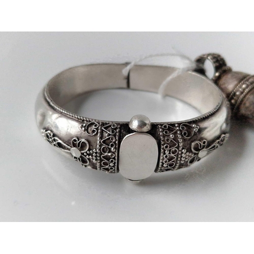 666 - A vintage silver tribal bangle together with silver hand of Fatima pendant