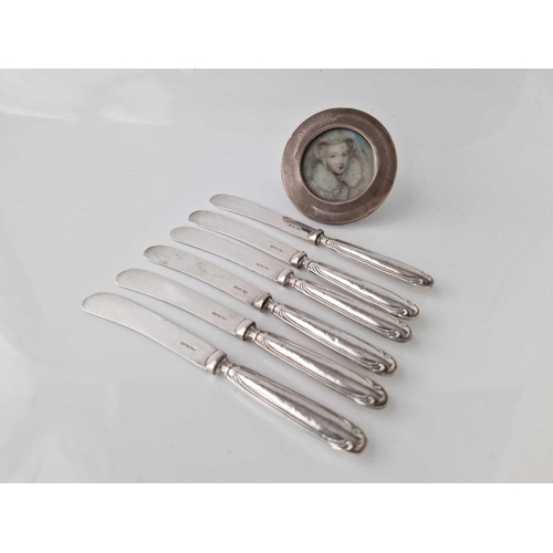 974 - Set of six silver handled tea knives and a circular photo frame. 3 in diam.