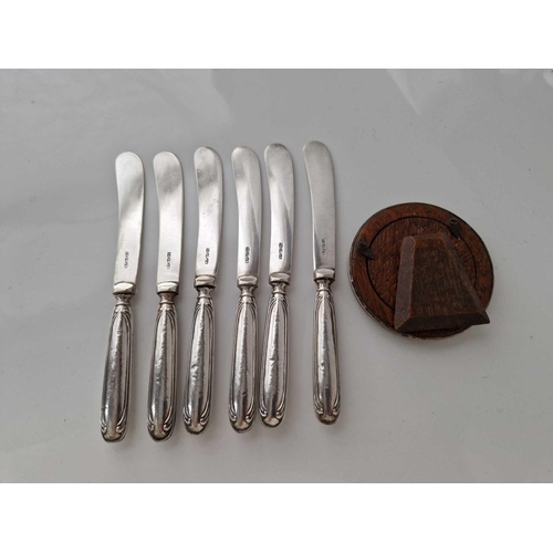 974 - Set of six silver handled tea knives and a circular photo frame. 3 in diam.