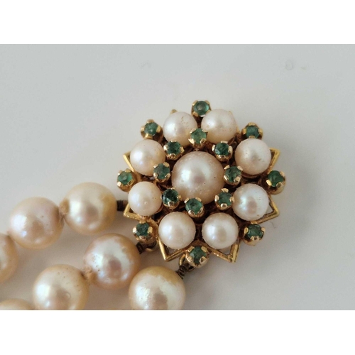 183 - A triple row pearl bracelet with 9ct pearl and emerald clasp