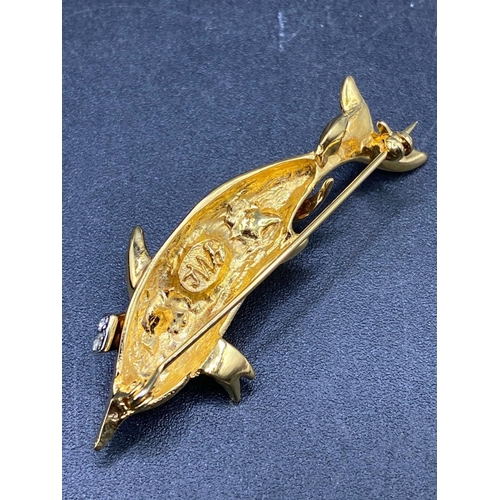 311 - A flying dolphin brooch with gem set body and eye with makers mark