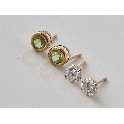 522 - A pair of peridot ear studs and pair of white stone ear studs, both 9ct