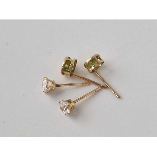 522 - A pair of peridot ear studs and pair of white stone ear studs, both 9ct