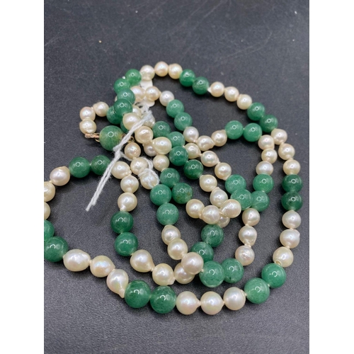 364 - A LONG PEARL AND JADE NECKLACE WITH 14CT GOLD CLASP 34 INCH