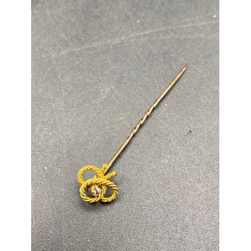 45 - A Vintage rope twist stick pin with diamond feature set in gold