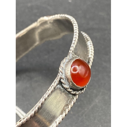 119 - A large silver and carnelian set bangle