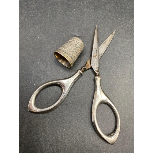 120 - A hallmarked silver handled pair of scissors and a thimble