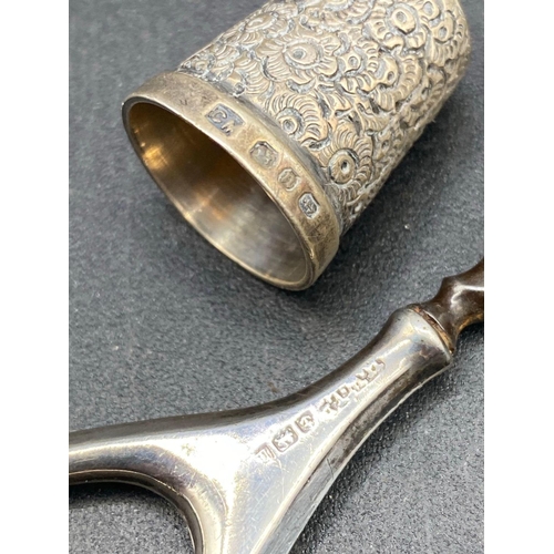 120 - A hallmarked silver handled pair of scissors and a thimble