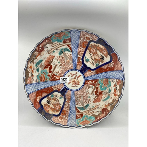 1624 - A Imari plate with decorated panels 13 inches diameter