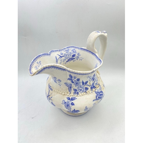 1625 - A 19th century blue and white jug painted with flowers 9 inches high