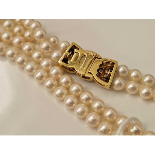 343 - A TWO ROW CULTURED PEARL NECKLACE ON A 18CT GOLD DIAMOND SET CLASP EACH PEARL 5.5 MM DIAMETER 18 INC... 