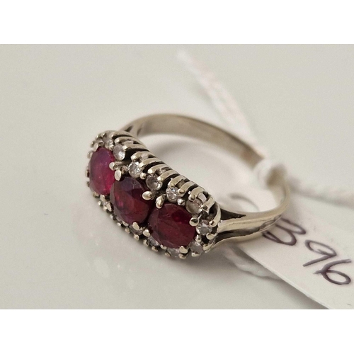 396 - A WHITE GOLD THREE STONE RUBY AND DIAMOND RING SIZE O 18CT GOLD 3.6 GMS