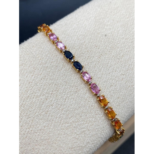 470 - A PRETTY SAPPHIRE LINE BRACELET WITH BLUE ORANGE YELLOW RED AND GREEN SAPPHIRES 18ct gold 7.5 inches... 