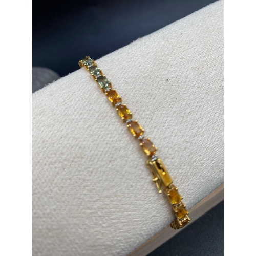 470 - A PRETTY SAPPHIRE LINE BRACELET WITH BLUE ORANGE YELLOW RED AND GREEN SAPPHIRES 18ct gold 7.5 inches... 