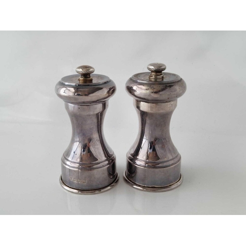 844 - A good pair of pepper mills with concave shaped bodies, 3.5 inches high, Birmingham 1954