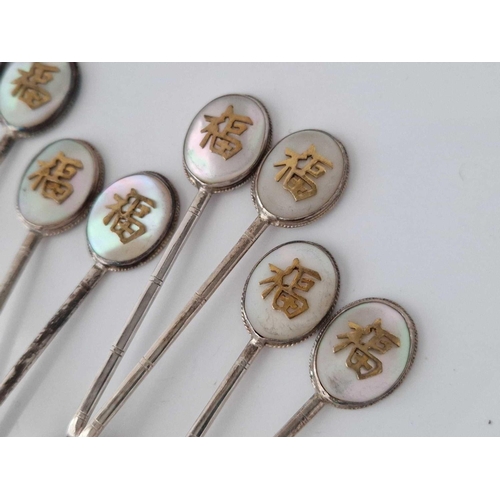 849 - A set of eight Chinese and MOP decorated topped spoons, stamped sterling, 61 g.