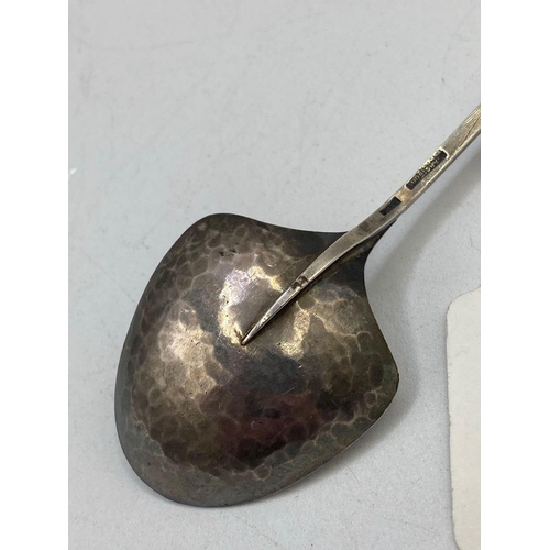 961 - A stylish art nouveau style spoon with hammered bowl, inset with garnet?