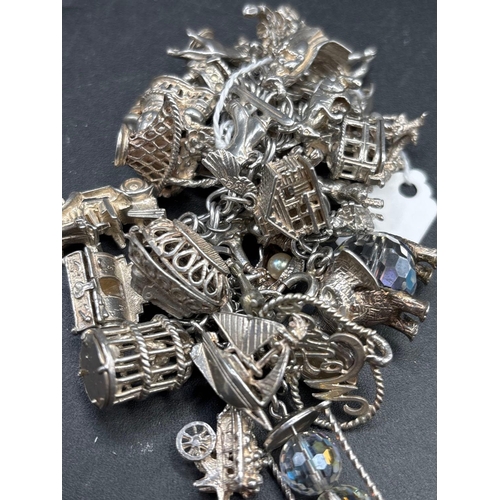 111 - An exceptional very heavy silver charm bracelet with over 30 charms 133 g.