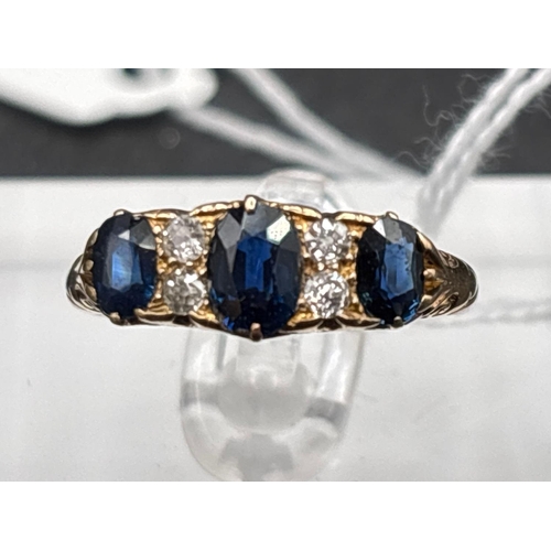 52 - A VICTORIAN SAPPHIRE AND DIAMOND THREE STONE RING WITH SCROLLED SETTING 18CT GOLD SIZE R 4.4 GMS BOX... 