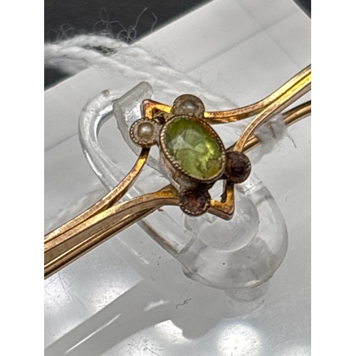4 - A peridot bar brooch set in gold