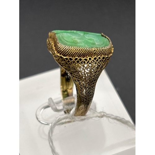 An oblong antique carved Jade ring in filigree mount 18x15mm
