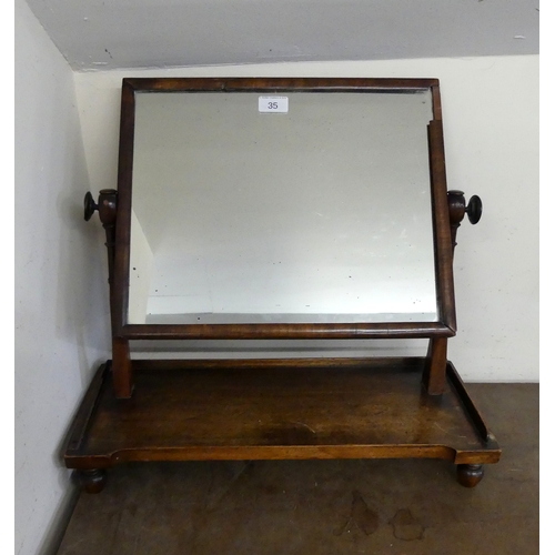 35 - A MAHOGANY SWING TOILET MIRROR