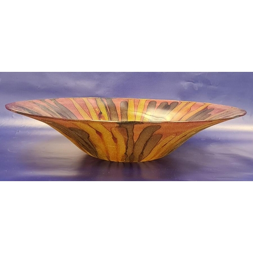 103 - Large modern glass bowl decorated with a pink ground and browns and gold stripes, the reverse with g... 