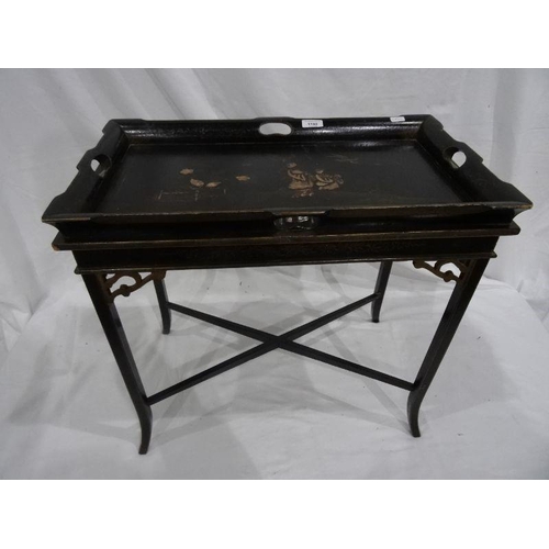 1192 - Lacquered tray-top table, the black ground with figural decoration, on stand with X-shaped stretcher