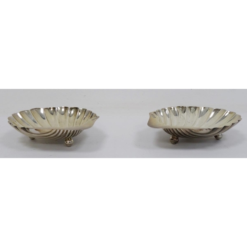 516 - Pair of early 20th century silver scallop-shaped dishes on bun feet, Sheffield, makers H&A, 4oz (2)