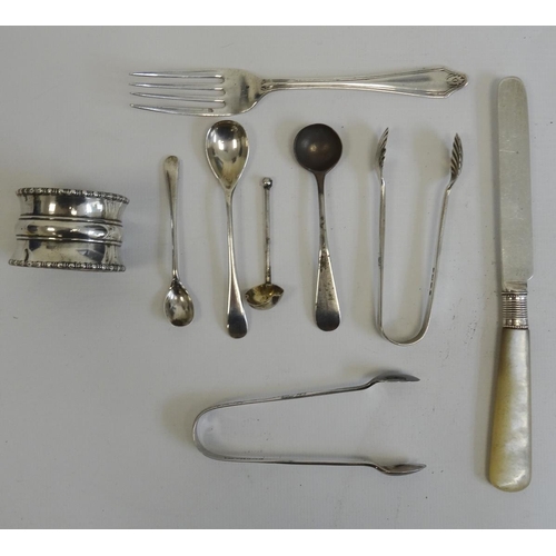 523 - Silver napkin ring, a small silver tea fork, two silver sugar nips, miniature spoons and a mother-of... 