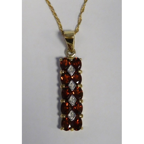 548 - 9ct gold pendant on chain set with trillion-shaped multi-coloured gem, a 9ct gold pendant set with g... 