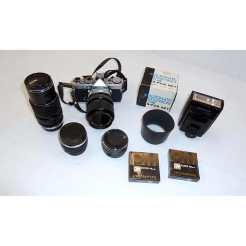 159 - Olympus OM-1 camera with four lenses, an electronic flash, filters, auto-zoom and instruction manual... 