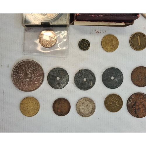 214 - An undated 20p coin and a small quantity of English and foreign coins in tin