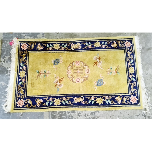 1353 - A Chinese wool rug, cream yellow ground with blue border decoration with blossom; measurements 149/9... 