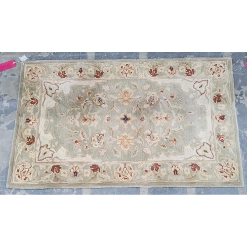 1354 - A modern rug with light green ground, floral decoration with brown and yellow flowers and leaves