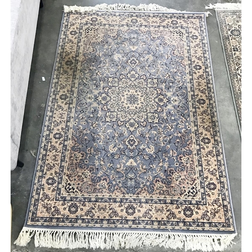 1363 - A Persian style wool rug,  light blue ground all over, floral decoration in pink, cream and dark blu... 