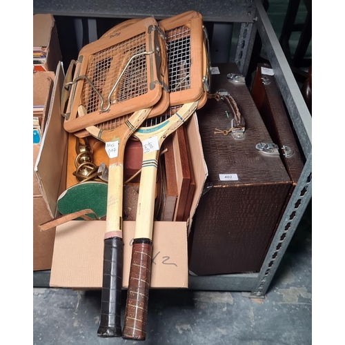 402 - Assorted books, a camera and a cased Singer sewing machine and two vintage tennis rackets