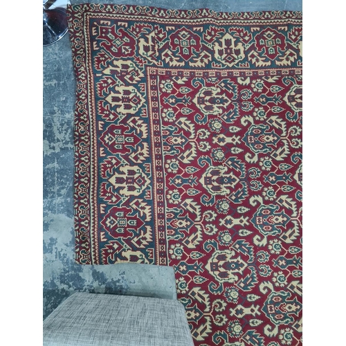 1034 - Heavily cut down rug, the red ground with allover foliate pattern, with alterations, notches, cut, e... 