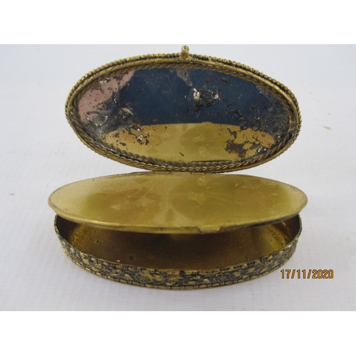 157 - Gilt metal box of oval form, the hinged cover set with paste stones, 8cm long x 7 cms wide