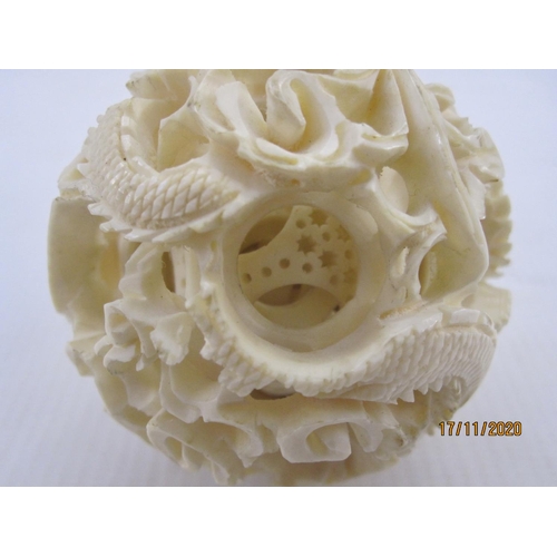 193 - Early 20th century Chinese carved ivory puzzle ball on stand with three graduated leaf-pattern tiers... 