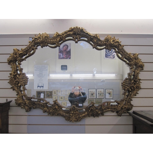 8A - Large gilt ornate mirror, shaped oval with floral foliate, scroll and shell relief borders, 107cm x ... 