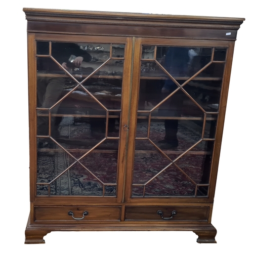 8 - Early 20th century mahogany glazed bookcase having stiffleaf and beaded borders to the pediment, fit... 