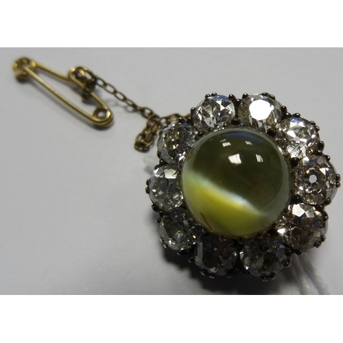 679 - Cat’s eye chrysoberyl and diamond cluster brooch set centre cabochon green stone having surround of ... 