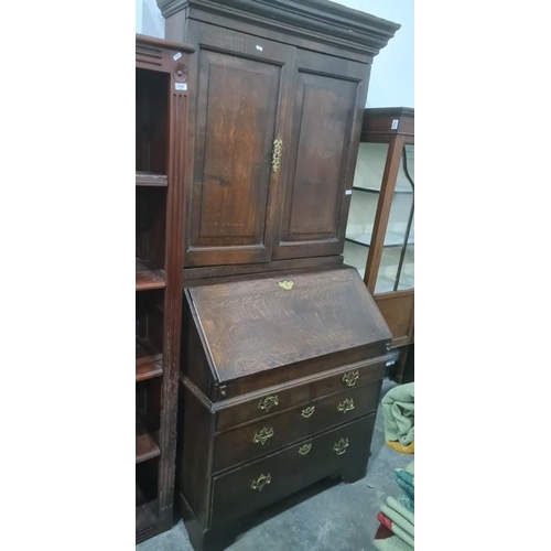 1102 - 18th century oak bureau bookcase with cavetto moulded cornice above two panelled doors enclosing she... 