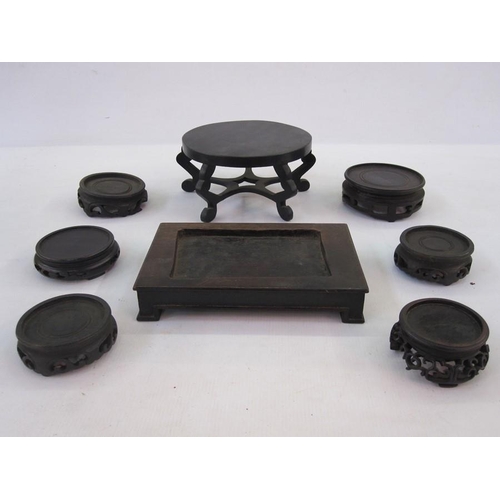 136 - Quantity of Oriental hardwood stands and an oval lidded box with hammered decoration