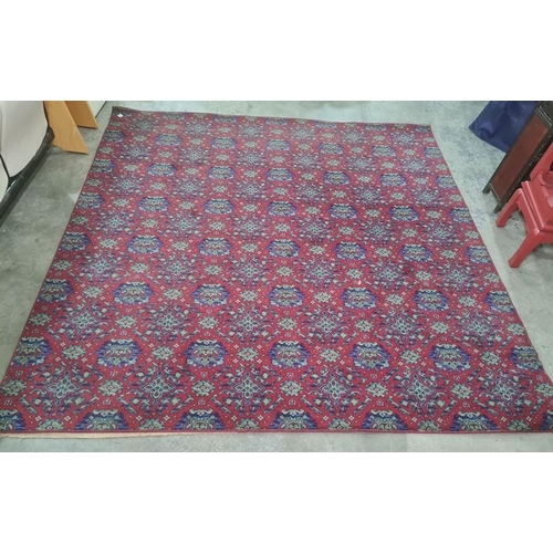 1265 - Large modern machine made red ground rug with all-over repeating green and blue pattern, 205 x 283cm