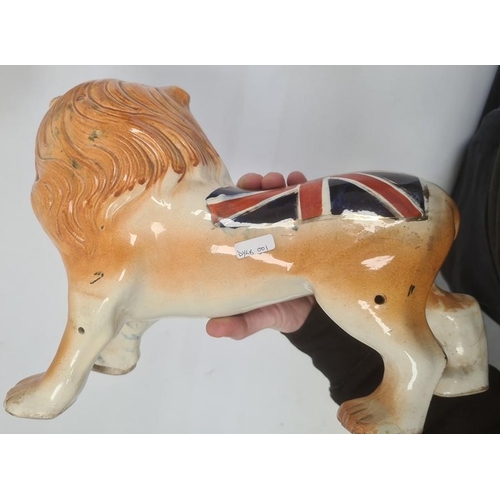 4 - Pair of Staffordshire-style pottery lions painted with Union Jacks, 25cm high x 32cm long (2)