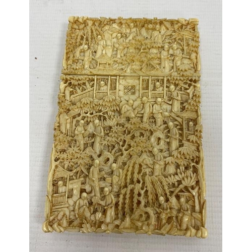 113 - A 19th century Chinese Canton carved ivory card case, relief of figures amongst buildings and trees,... 